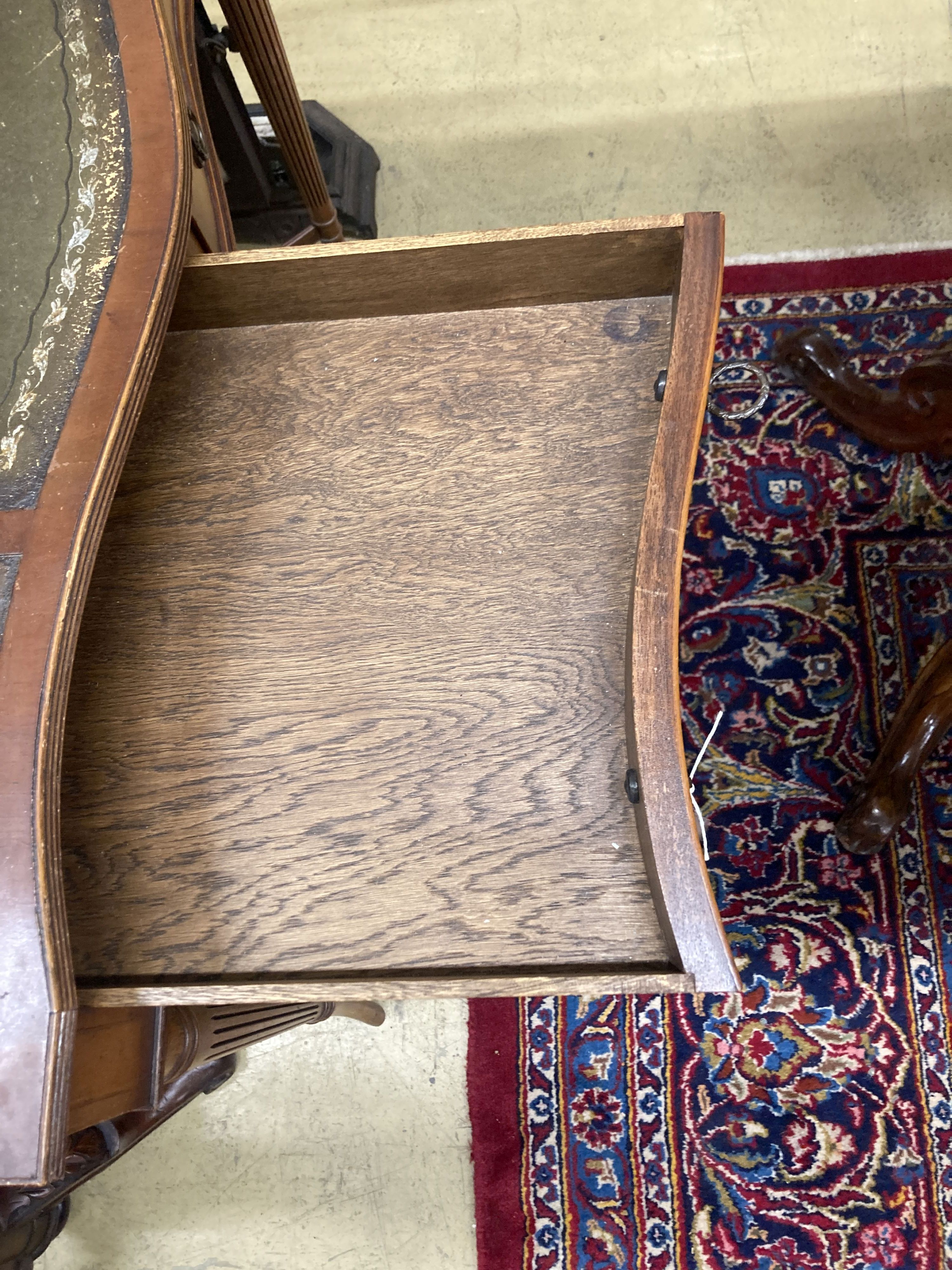 A reproduction yew serpentine writing table, width 92cm, depth 50cm, height 103cm